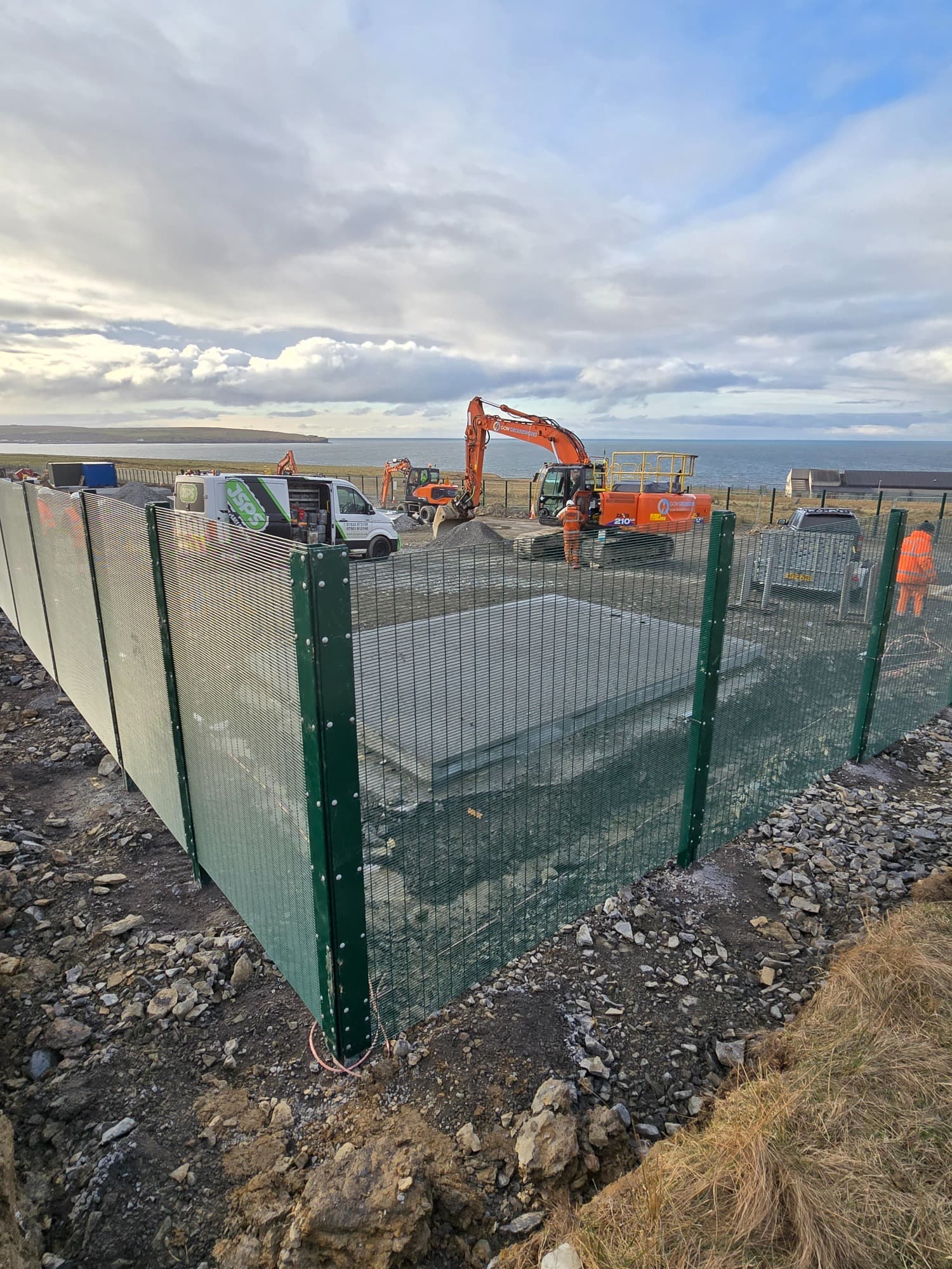 358-style mesh around a live construction pad, installed alongside other groundworks.