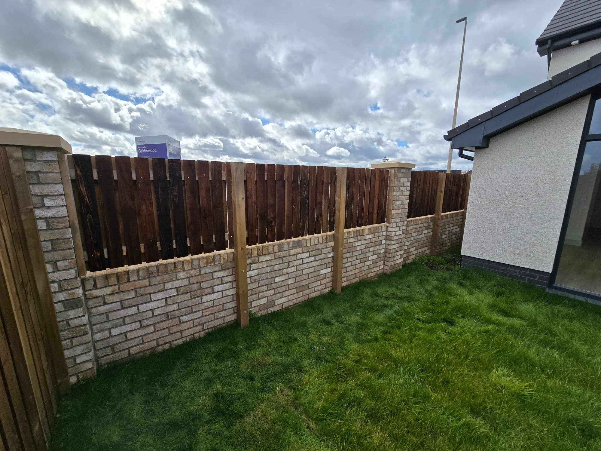 Masonry wall with dark timber infill and posts built into the brickwork.