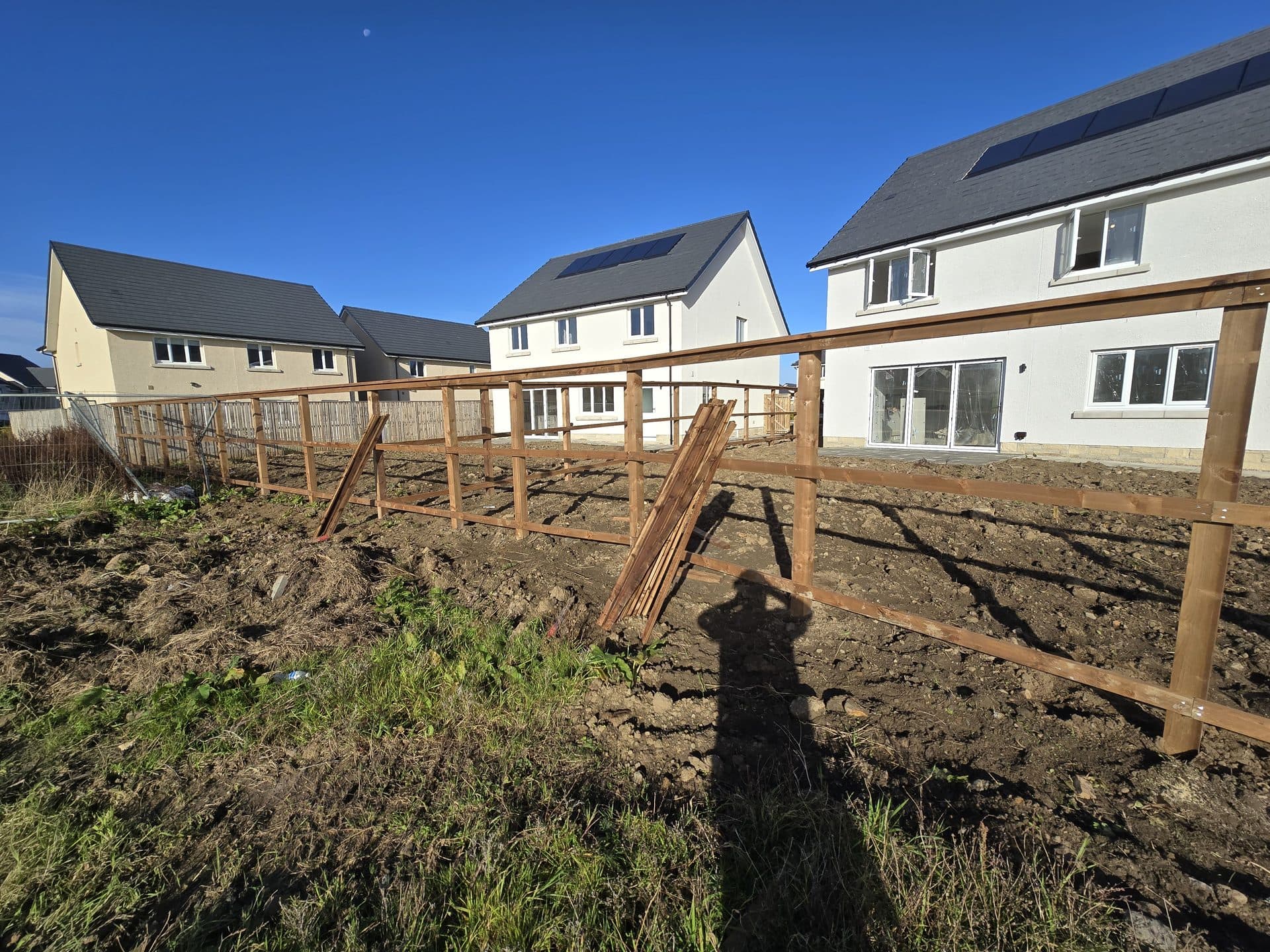 Timber posts and rails with boards ready to fix on an East Calder new-build plot
