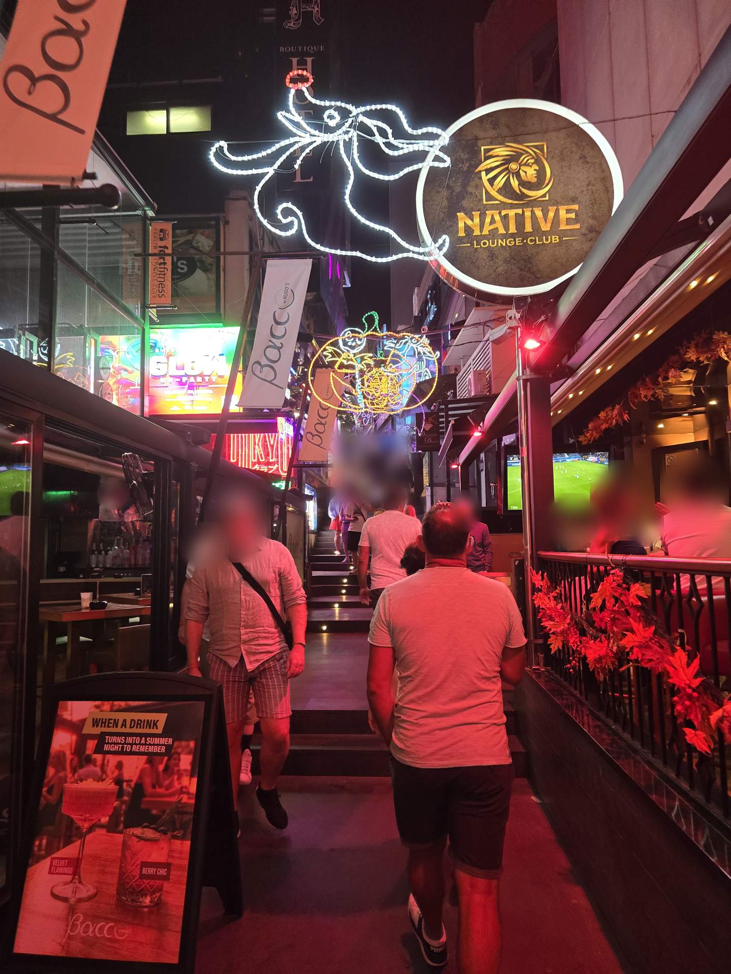 A lit street of bars at night in Malta