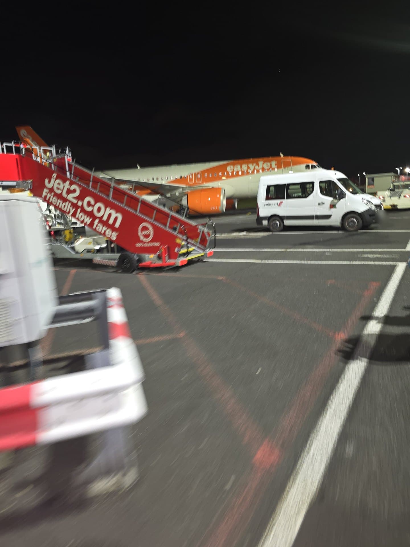 Night-time airport apron in Malta, with an easyJet plane and Jet2 stairs